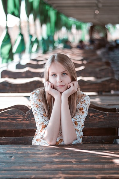 Young woman with chin in hands at outdoor table
